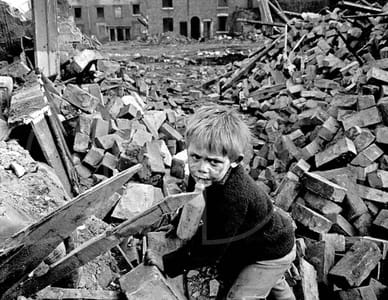 Verlassener Junge hält ein Stofftier inmitten von Ruinen nach deutschen Luftangriffen auf London, 1945