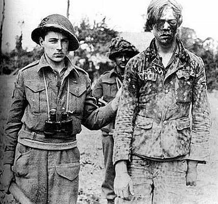 Kanadischer Soldat mit geschlagenem deutschen Kriegsgefangenen, Caen, 1944