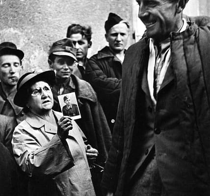 Eine Mutter zeigt einem heimkehrenden Kriegsgefangenen ein Bild ihres Sohnes, 1947