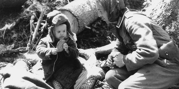 Deutscher Soldat gibt einem russischen Waisenjungen Brot, 1942