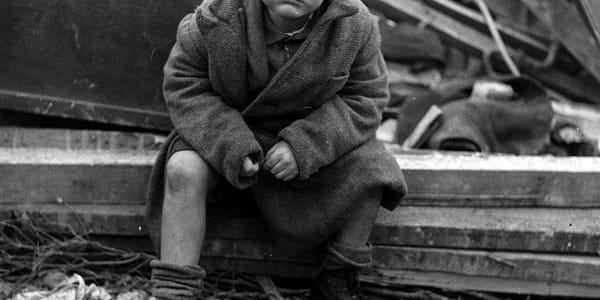 Verlassener Junge hält ein Stofftier inmitten von Ruinen nach deutschen Luftangriffen auf London, 1945